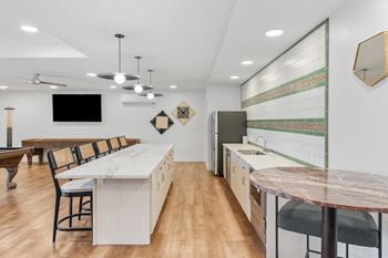 A kitchen with a white counter and a black chair.